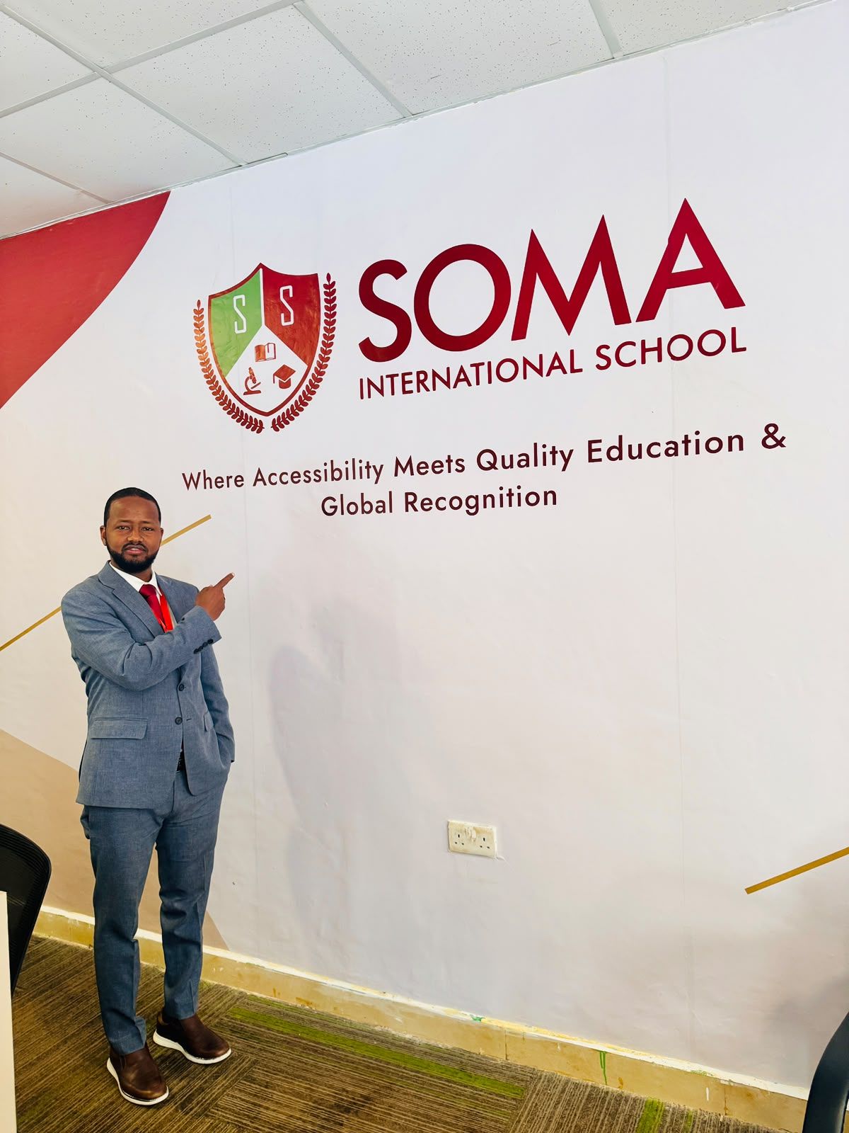 Guled Kabare, Director and CEO, beside the SIS crest
